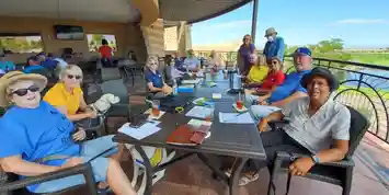 Smiling group seated at outdoor patio table