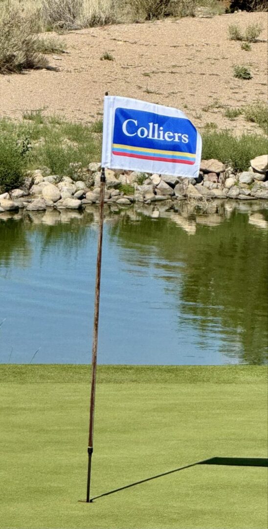 Golf flag with Colliers logo by pond