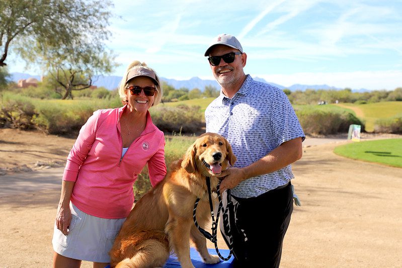 Couple with golden retriever on golf course